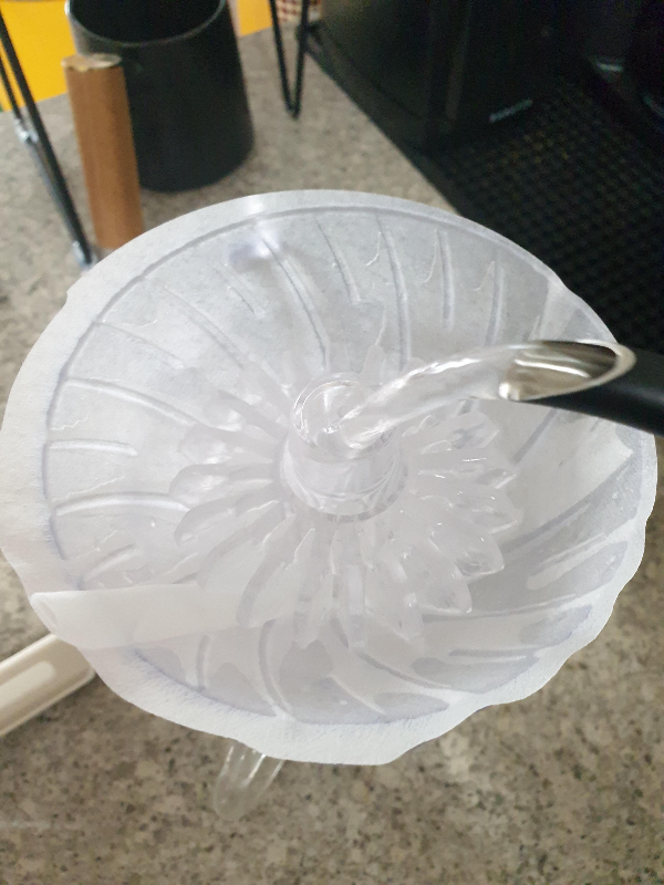 드리퍼 안에 린싱을 돕는 도구가 들어 있다. 드립포트로 뜨거운 물을 붓는 중