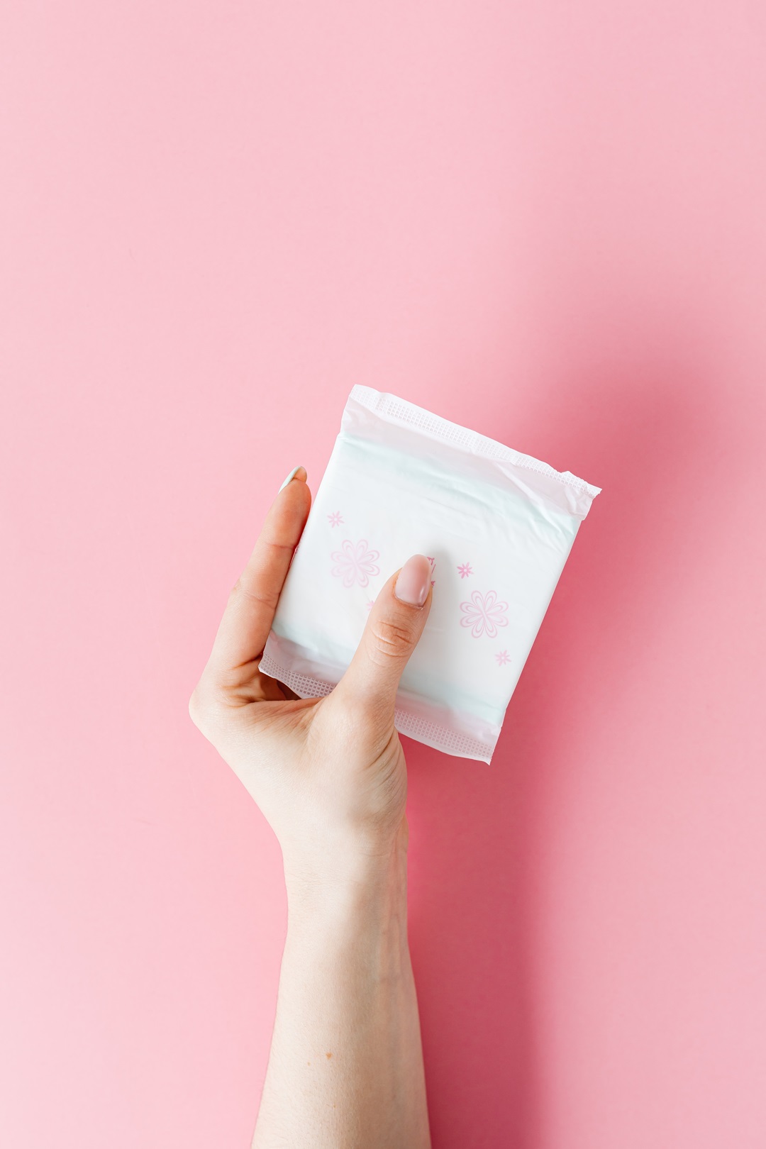 포장된 생리대 1개를 왼손으로 쥐고있는 사진