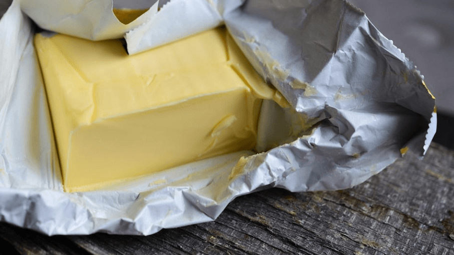 노란색 버터를 포장을 뜯고 있다