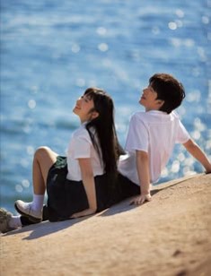 젊은-남여가-해변에-앉아-손으로-모래사장을-짚고-하늘을-바라는-모습