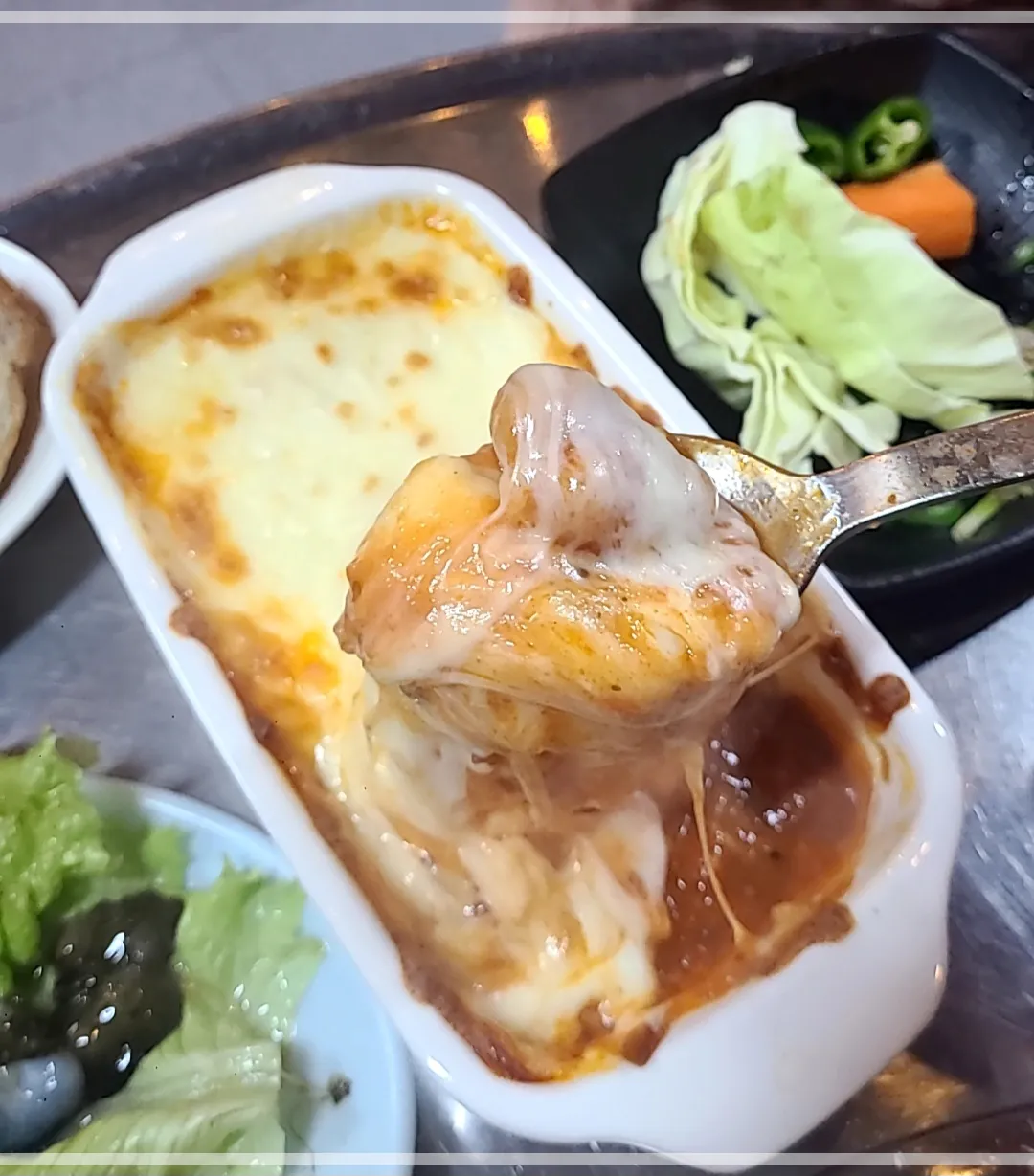 네모난 흰접시에 키조개토마토관자구이를 한수저 들어올린 모습.