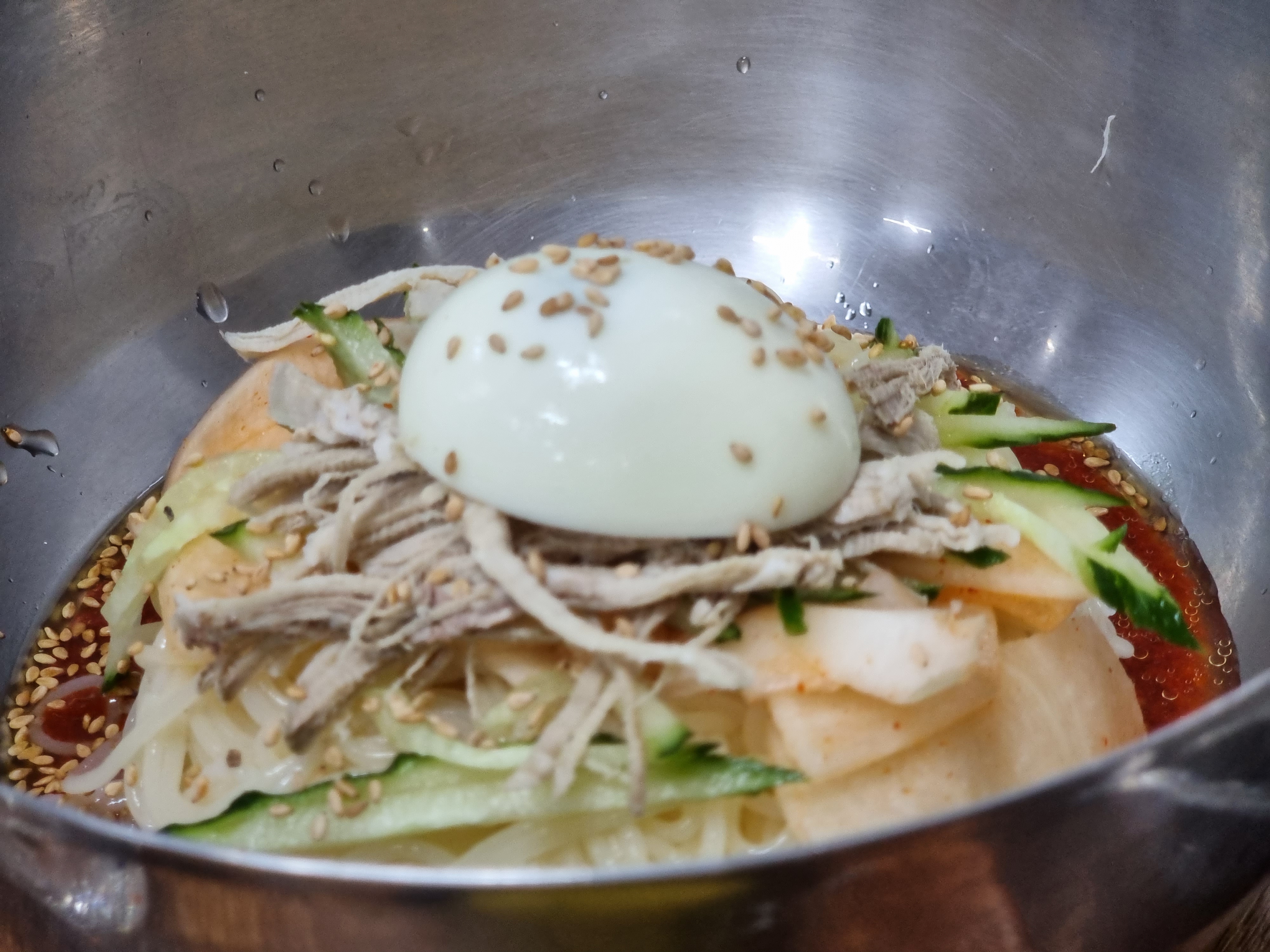 양념이 듬뿍 올라간 비빔밀면. 참기름 향이 코끝을 자극합니다.