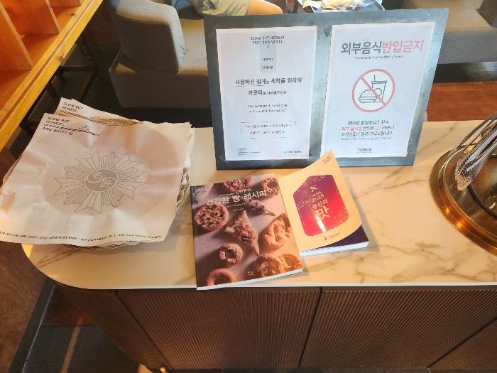 There are bread tongs and a plate on the table.