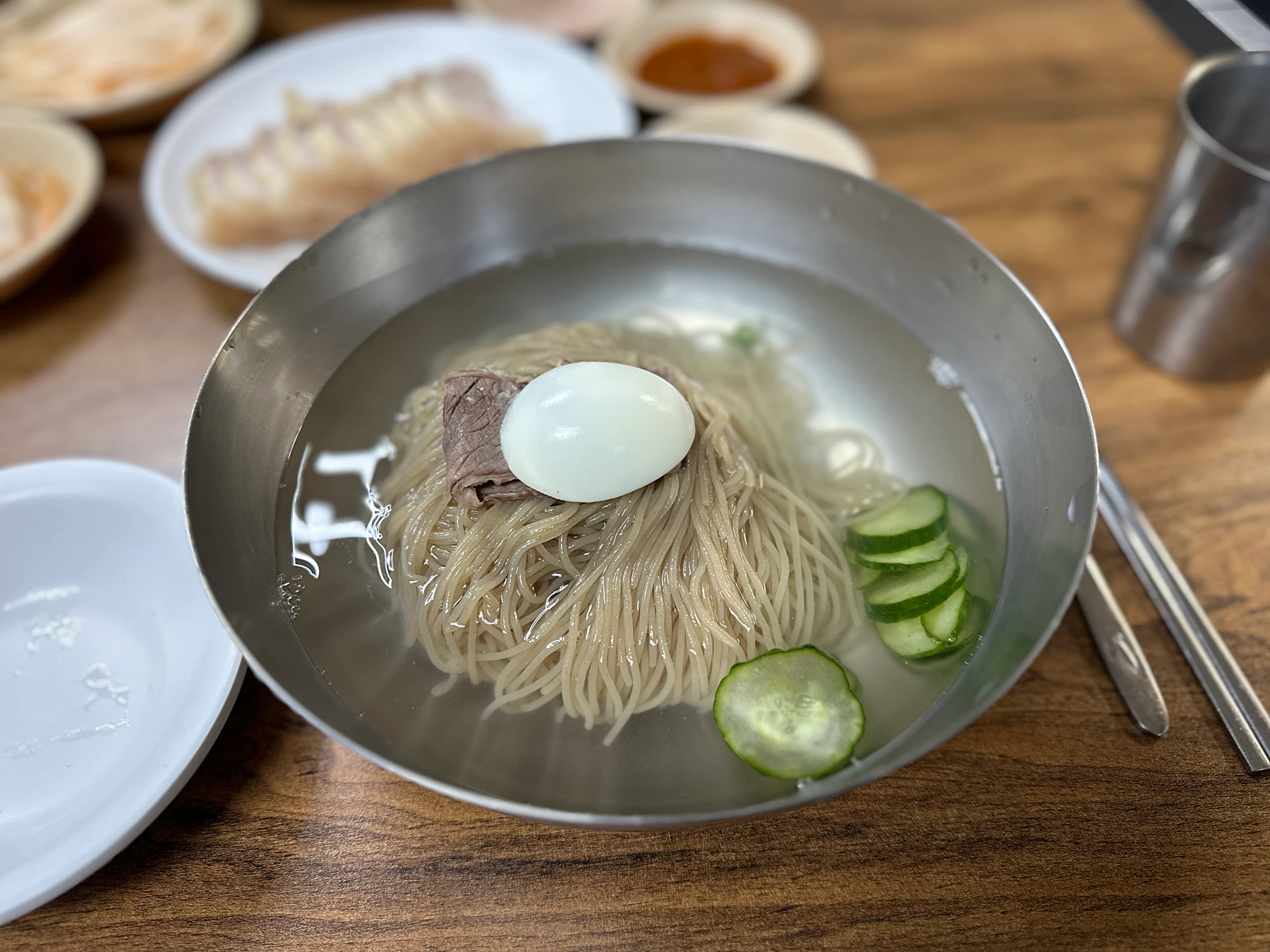평양면옥-물냉면-나에게는-메밀면과-맑은육수-고기와계란이-고명으로들어가있고-오이도-몇개가들어있다