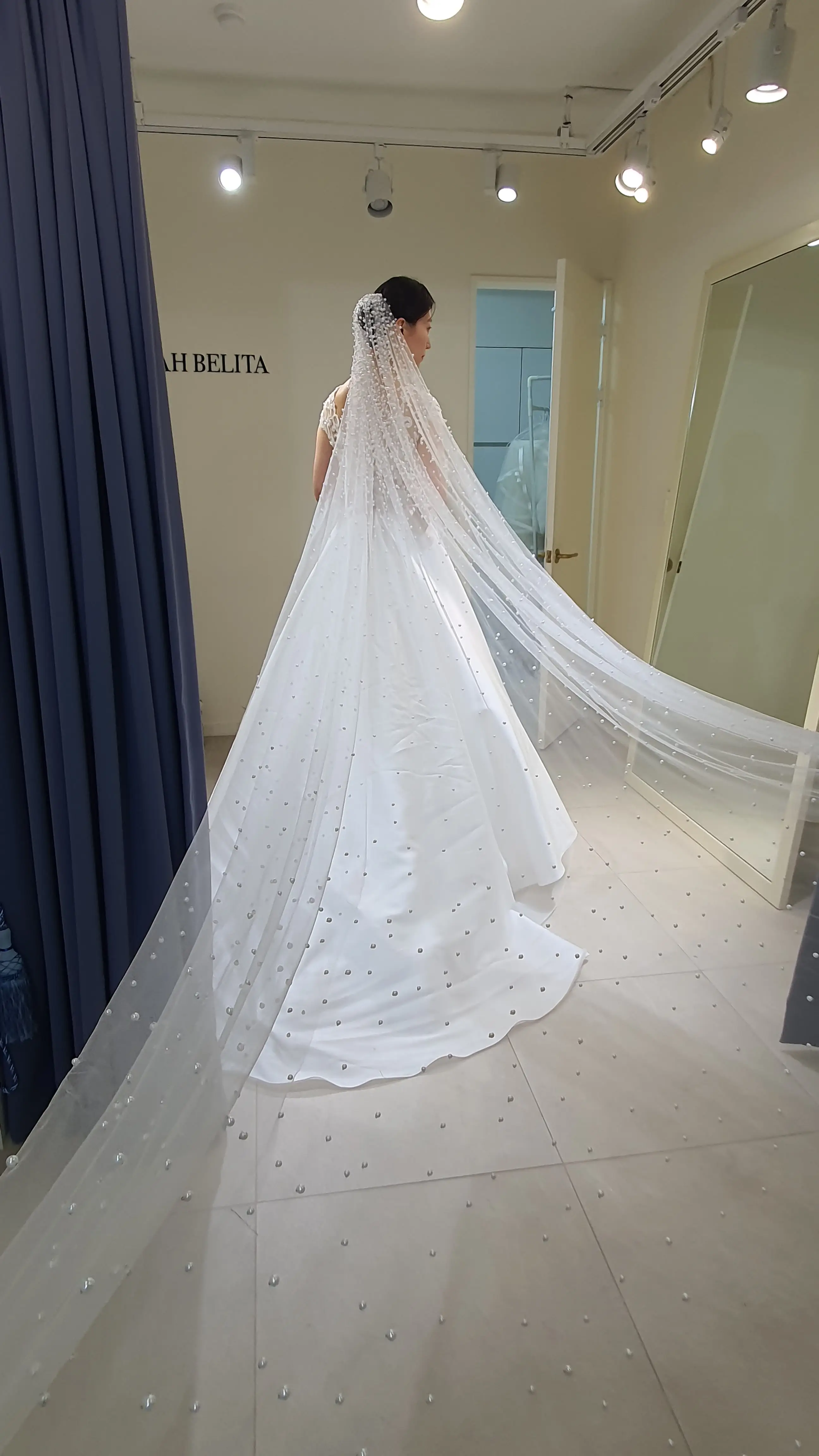 노바벨리타-상의-레이스-치마-실크인-허리선이-높고-디자인이-유니크한-드레스-입고-베일-펼친-뒷모습