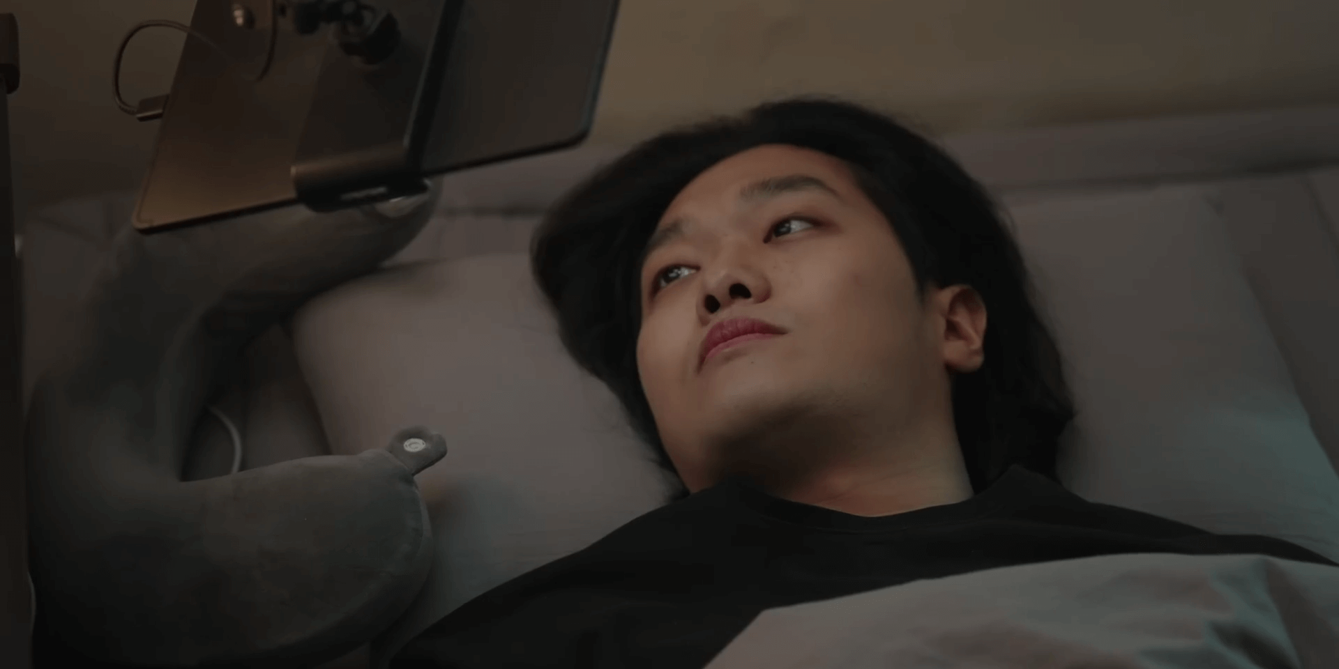침대에 누워서 유튜브 보는 남자