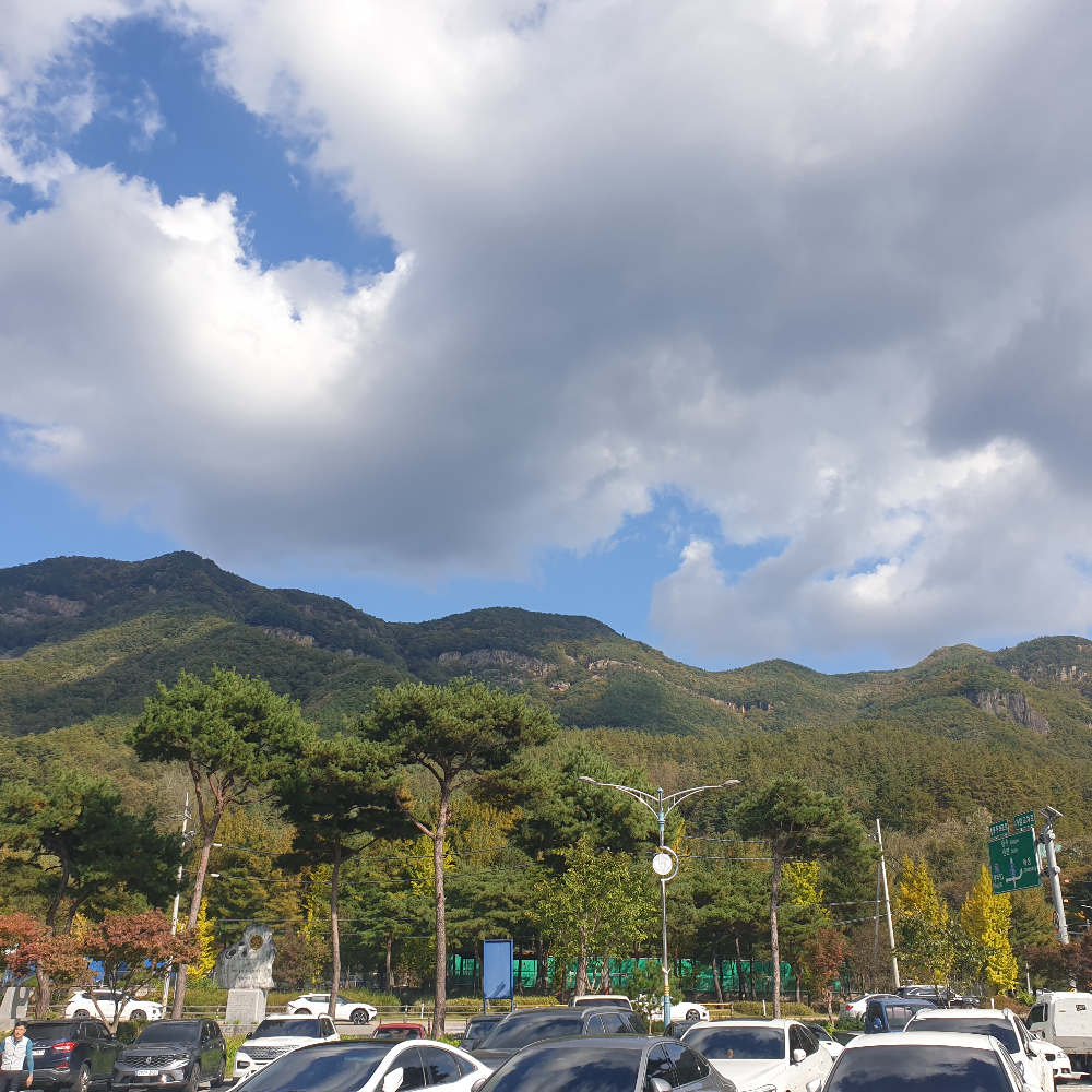 높은 산 그리고 산 위로 파란 하늘과 구름이 보인다.