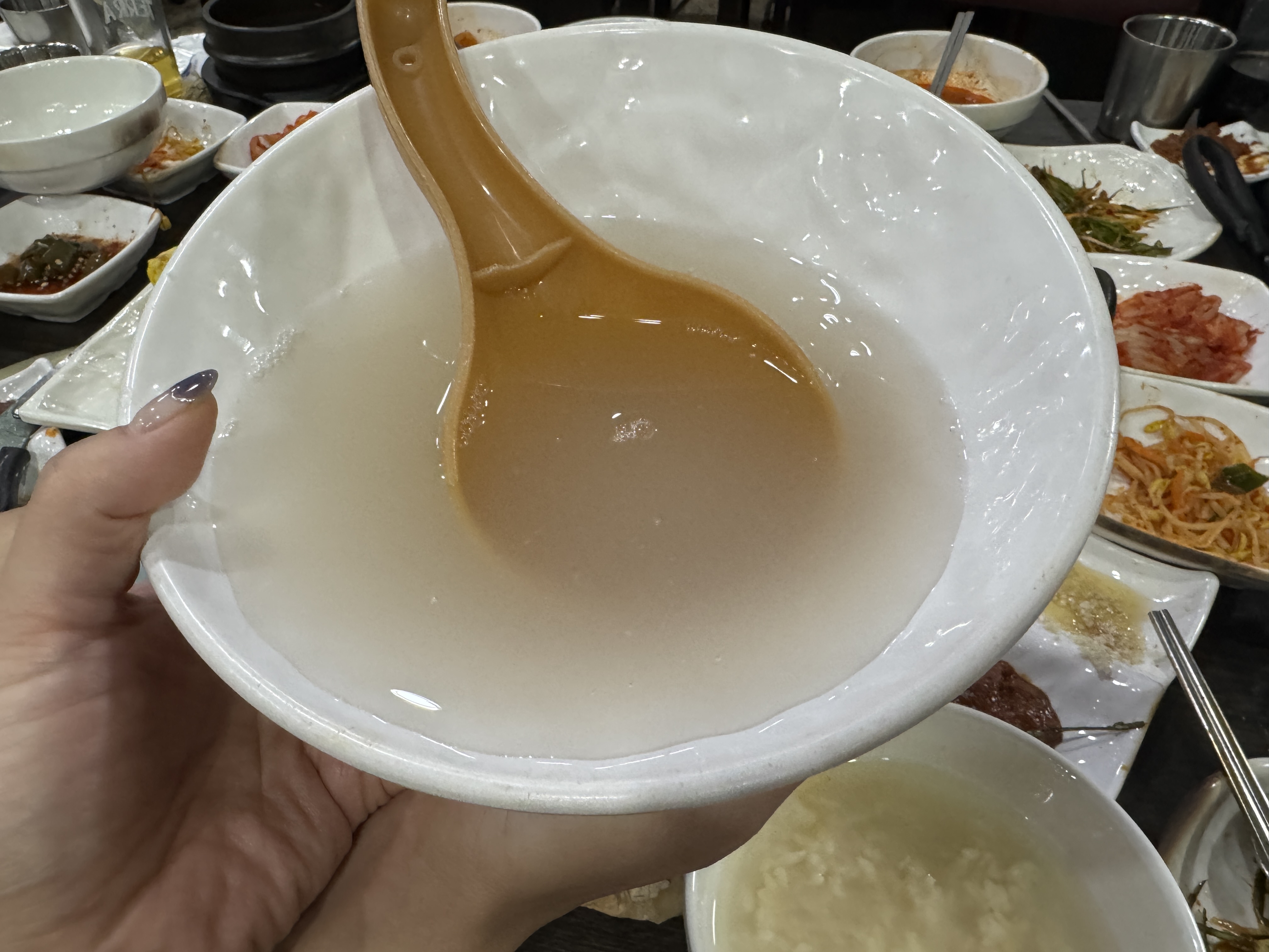 직접 만든 식혜가 담긴 흰 그릇을 들고 있는 모습. 맑고 덜 단 식혜의 색감이 깔끔하다. 