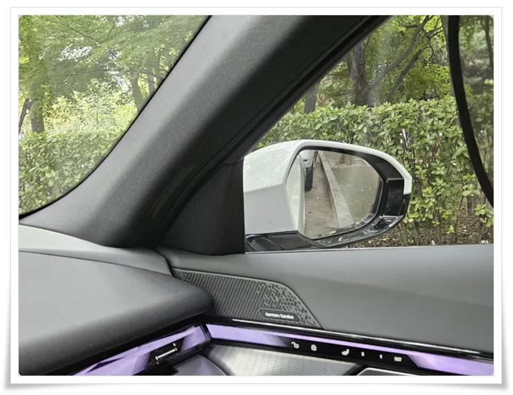 BMW G30 후진 기어에서 자동 연석 감지로 미러가 아래로 내려가 연석과 휠 간격을 보여주는 장면