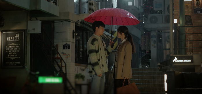 내리는 빗속에서 우산을 쓰고 있는 남녀