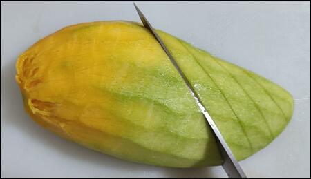 사선으로 망고에 칼집을 내는 모습