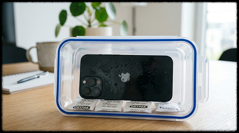 실리카겔과 함께 스마트폰을 밀폐 용기에 넣어 습기를 제거하는 모습