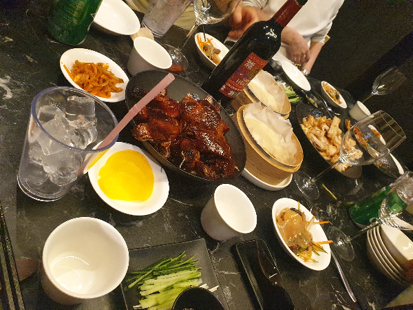 검은색 테이블 위에 베이징덕과 꿔바로우 등 다양한 음식들이 올려져 있다.