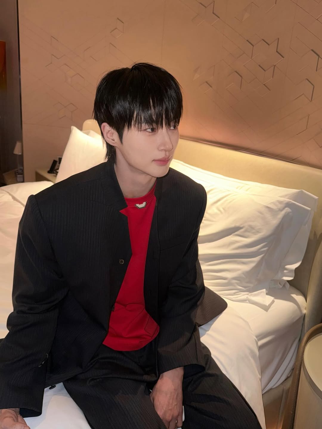 검정 수트(빨간 이너)를 입고 앉아있는 변우석