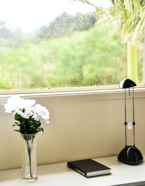 창문 밖으로 비내리는 모습이 보이는 거실 안 모습