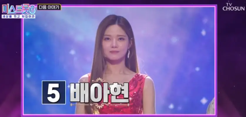 미스트롯3-
보라색 배경 가운데 밝은 보라색 무대 가운데 빨간 드레스에 긴머리를 늘어뜨린 채 왼쪽 하단 검은 네모 안 흰클씨 5 검은네모 밖 흰글씨 배아현