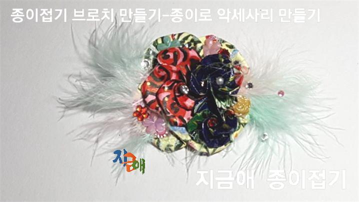 큰 꽃 위에 작은 꽃 3개를 접어 포개어 붙여 주었으며 반작이는 큐빅과 스티커를 붙여 주었습니다