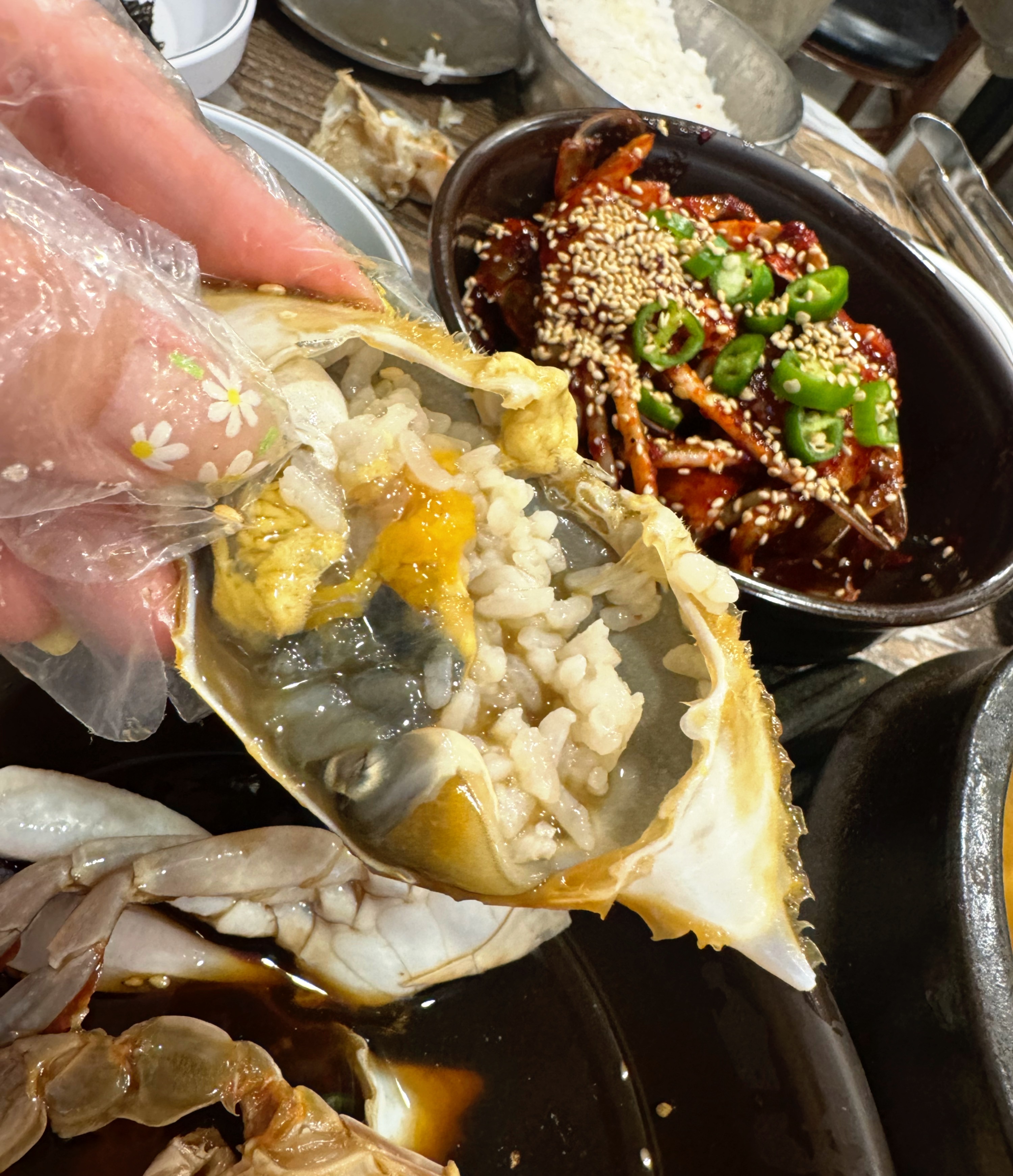 게 등딱지에 비벼먹는 밥 사진. 내장과 양념이 섞여서 하나의 요리처럼 보인다.
