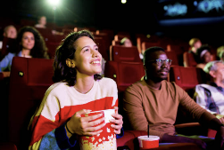 영화관에서 팝콘을 손에 들고 영화를 보는 여성과 옆에 남성