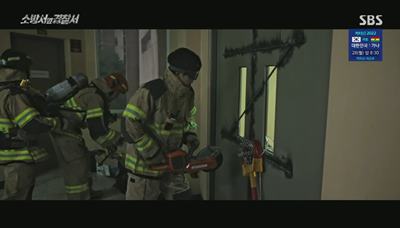 잠긴 문을 부수고 있는 소방대원