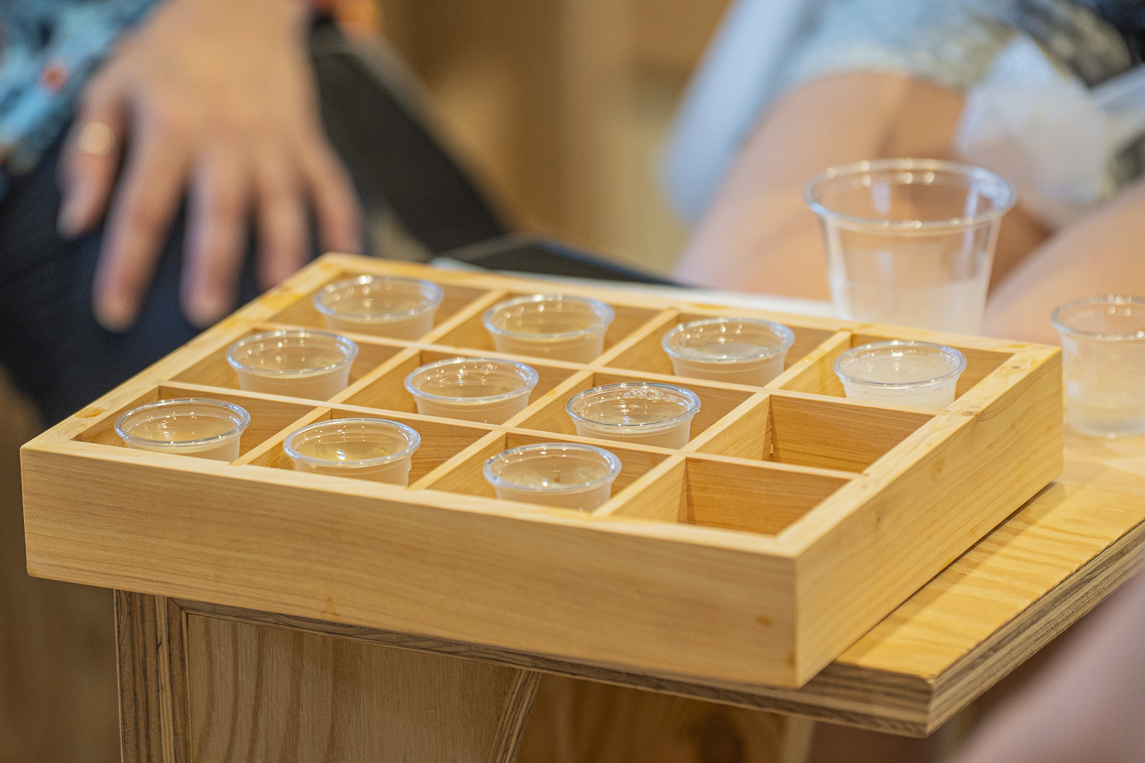 Kyo no Sake Café Jusan Hachi: small sake-tasting cups arranged in a divided wooden tray.