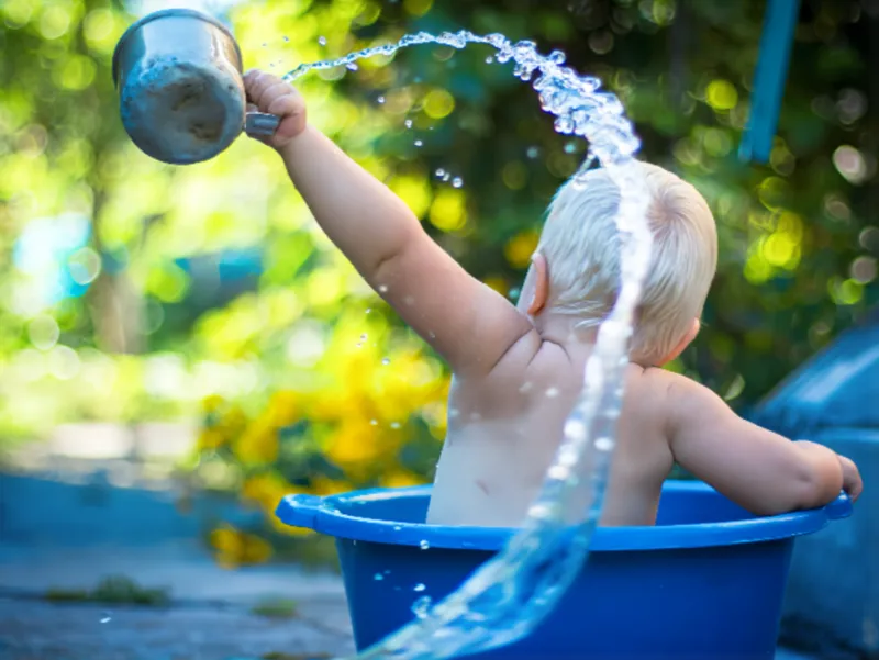 물장난을 즐기는 아기의 역동적인 뒷모습