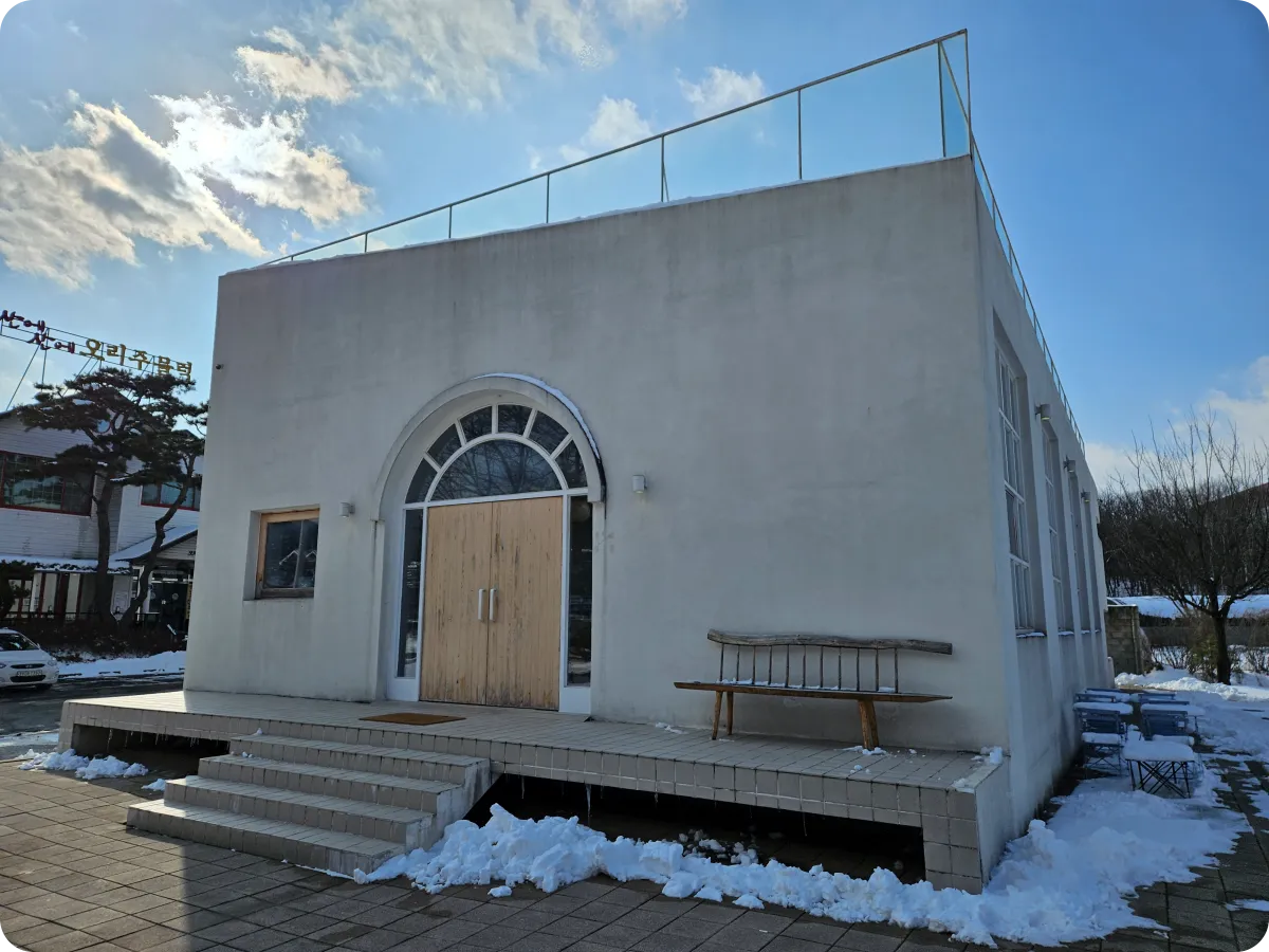 경기도-여주-맑은-하늘-아래-카페-우즈-외관-대형-출입구-앞-나무-벤치