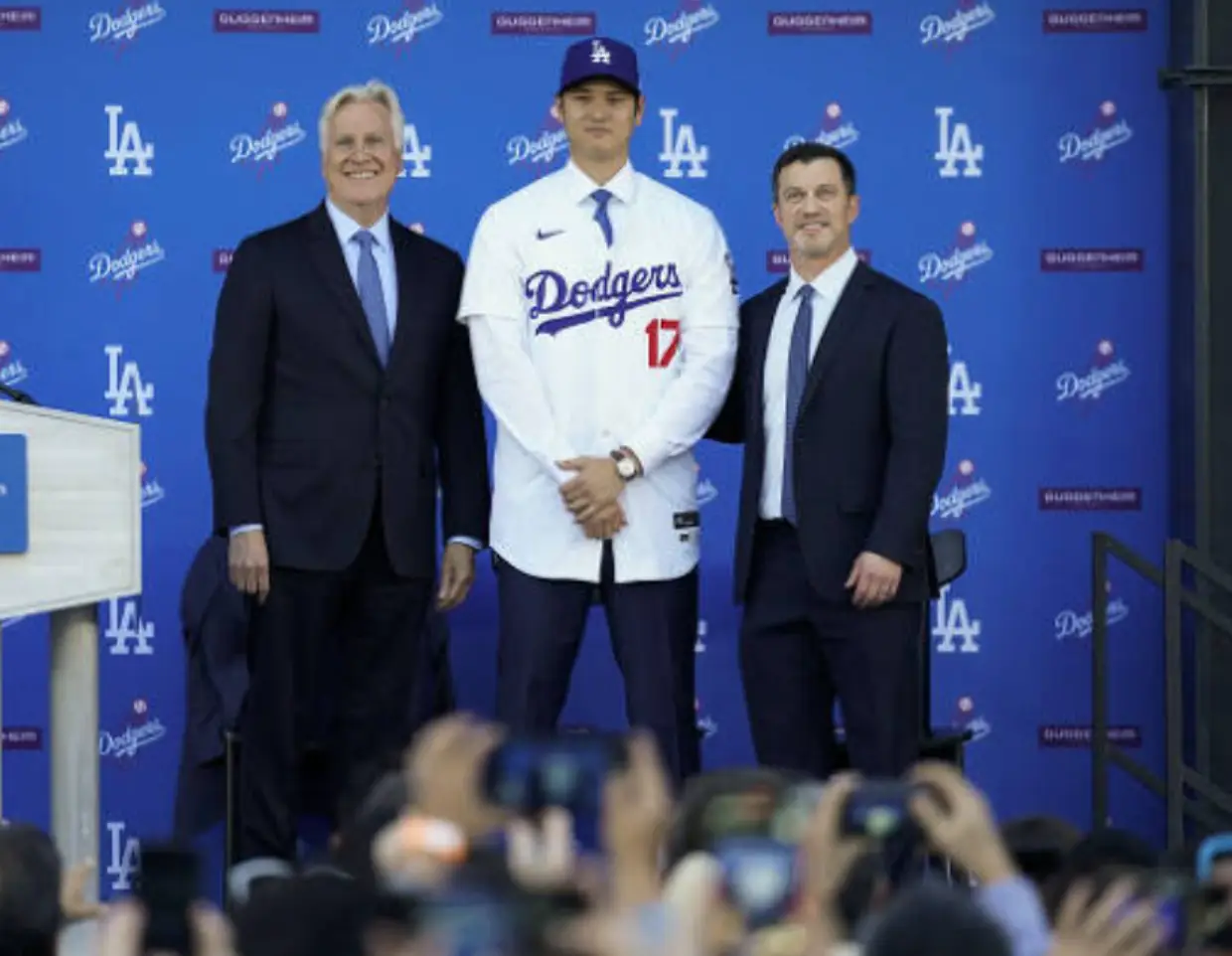 오타니-LA다저스 벽 앞 정장을 입은 두 신사 사이 흰유니폼을 입고 서있는 오타니