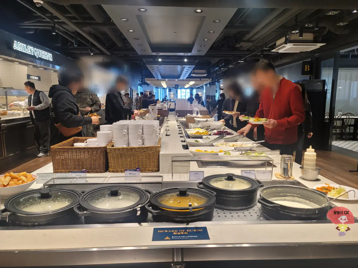 경기-남양주시-다산점-에슐리퀸즈-음식코너에서-음식과-스프를-담고있는-사람들