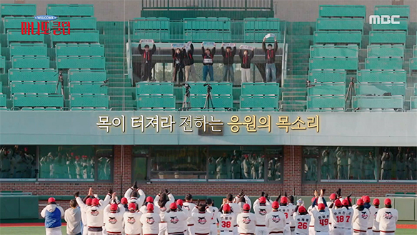 야구장 관중석의 출연진과 그라운드의 선수들이 함께 응원하는 장면