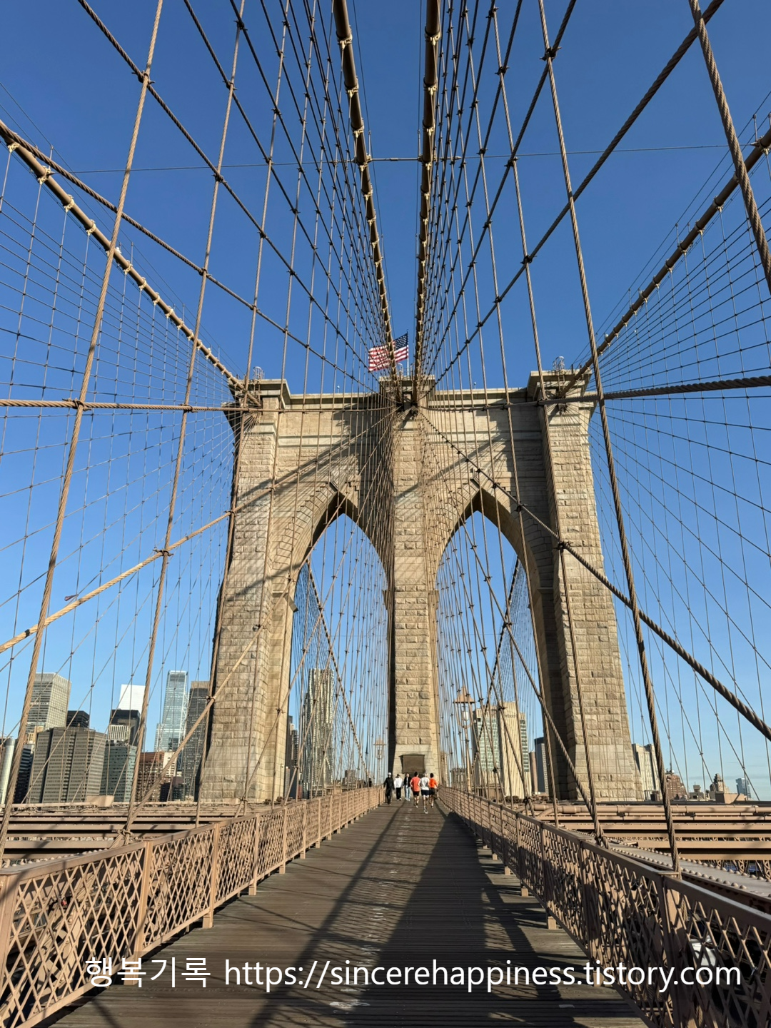 아침 7시 반 한산한 브루클린 브릿지 위에서 바라본 웅장한 석조 아치와 보행로