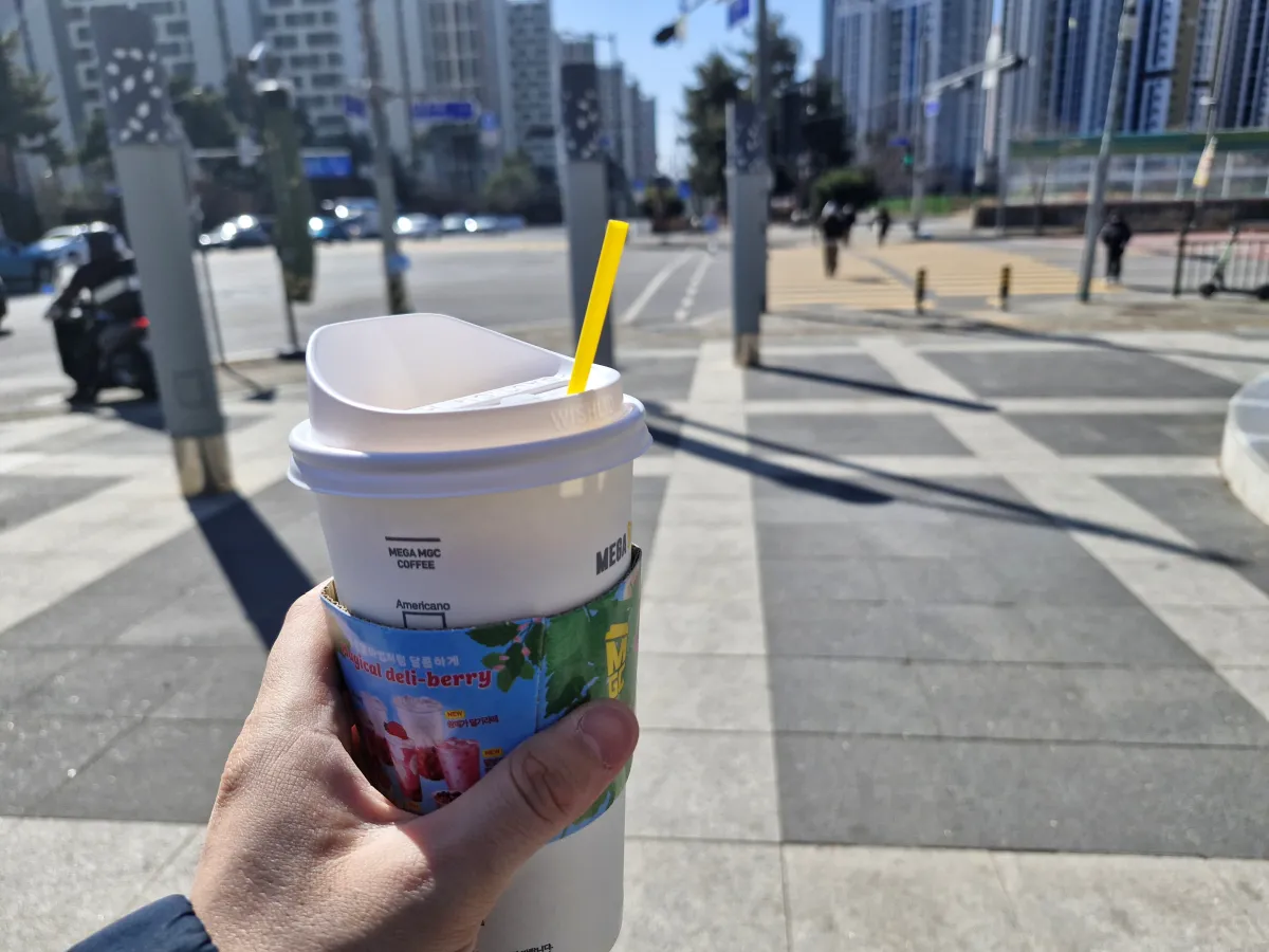 야외에서-커피를-한손으로-들고있는-남성