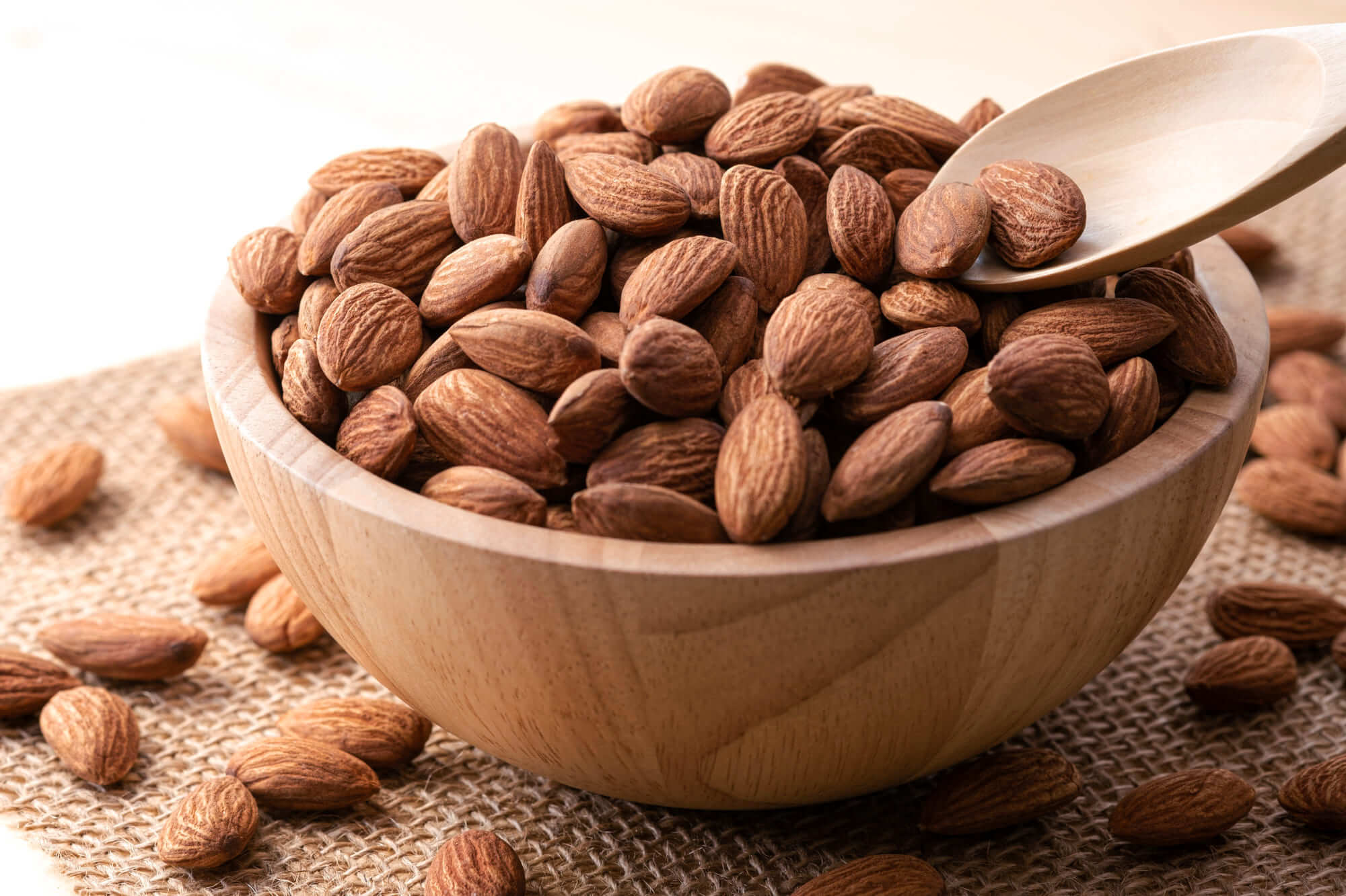 나무 그릇에 담긴 통아몬드와 숟가락, 면역력과 영양에 좋은 간식