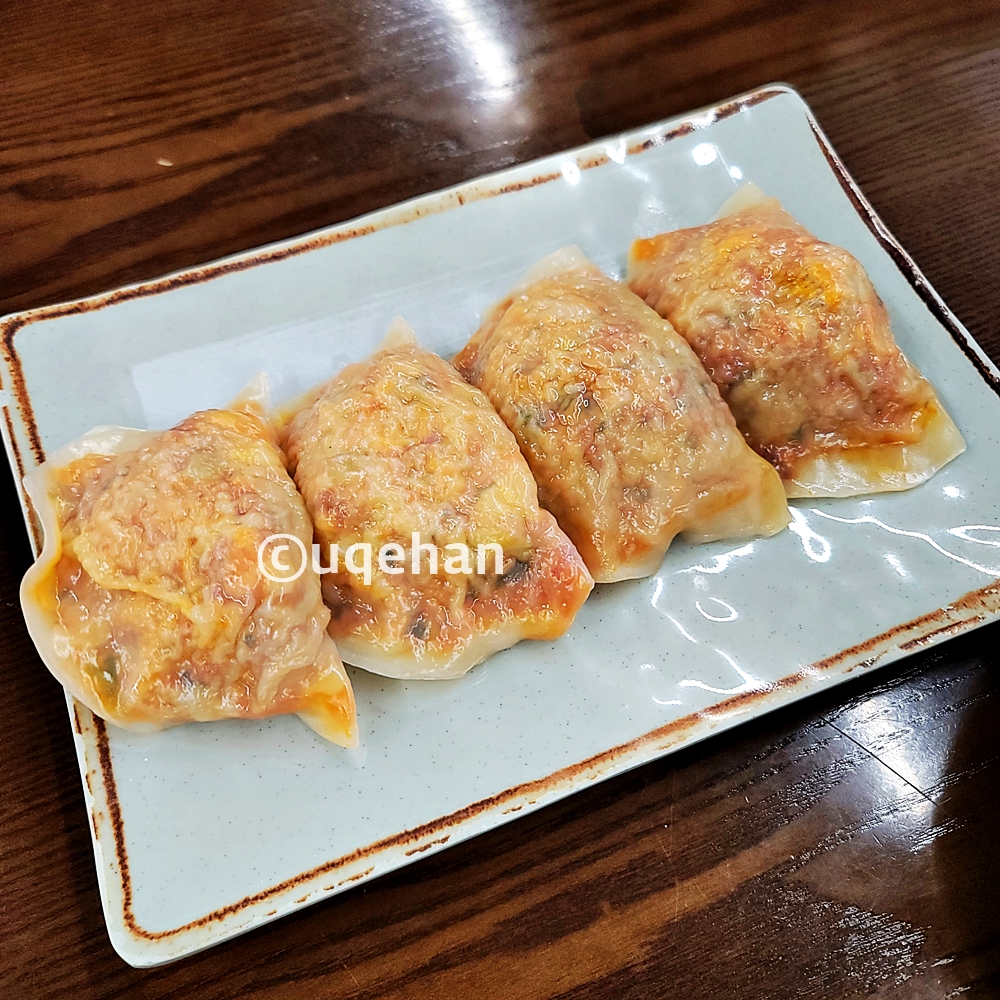 접시위에 김치만두 4개가 놓여있다.