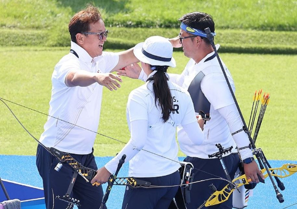 지난해 8월 2일(현지시간) 프랑스 파리 레쟁발리드에서 열린 2024 파리올림픽 양궁 혼성 단체 독일과의 결승전에서 승리한 한국 김우진과 임시현을 박성수 감독이 환한 미소로 맞이하고 있다. [사진=연합뉴스]