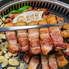 맛있는-삼겹살-5개를-한젓가락으로-집는-장면