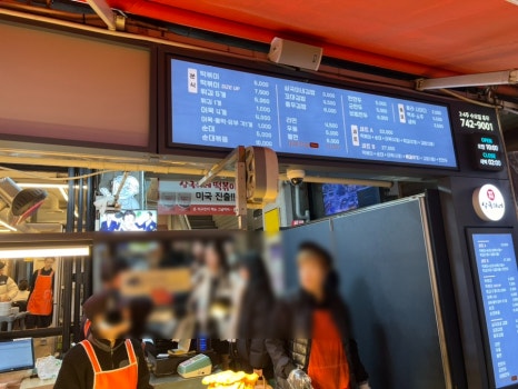 해운대시장 상국이네 분식집 메뉴판 사진, 떡볶이와 튀김을 중심으로 한 다양한 분식 메뉴와 가격이 안내된 모습
