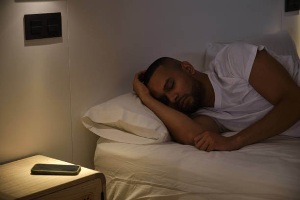 침대옆에 핸드폰을 옆에 두고 자는 남성