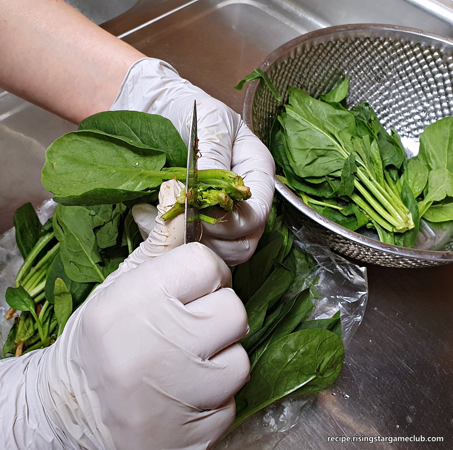 시금치나물 무침을 하기 위해서 시금치를 반으로 자르는 사진