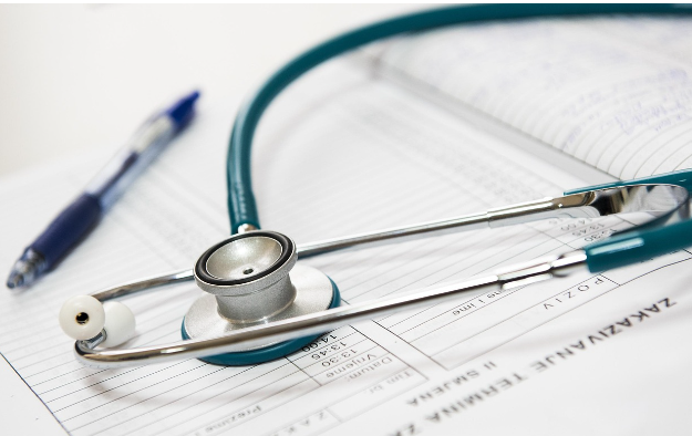 청진기와 건강검진 결과 리포트가 놓인 의료 서류