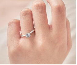 네번째 손가락에 다이아 반지를 끼고 있는 여자 손