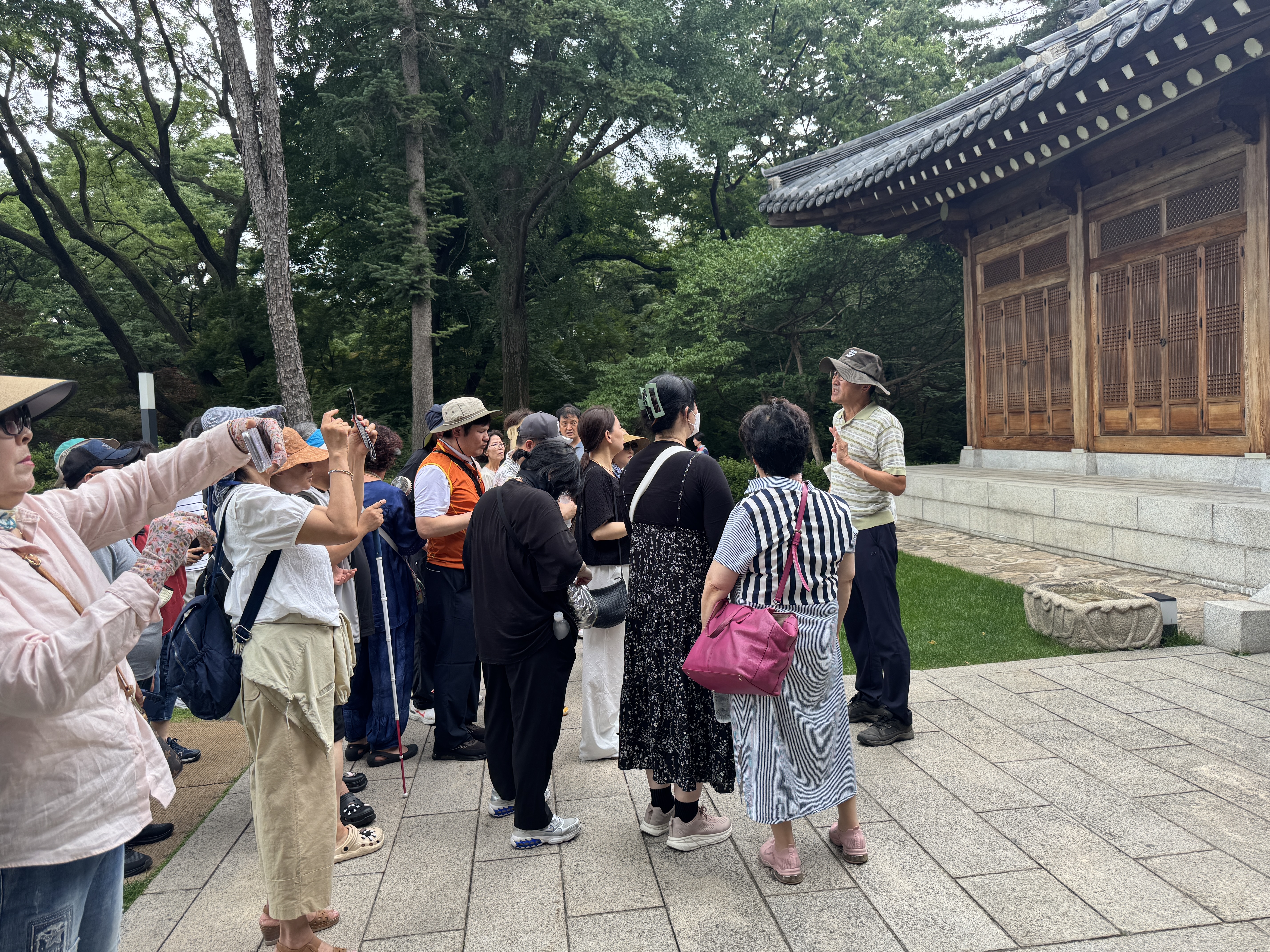 청와대의 건물에 대해 설명하고 계시는 해설사와 설명을 듣는 지회원들의 모습