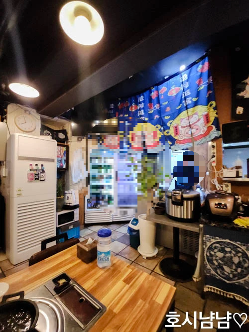 하남 920숙성회 주방 전경 - 사장님이 조리를 준비 중인 주방과 일본식 장식이 어우러진 모습