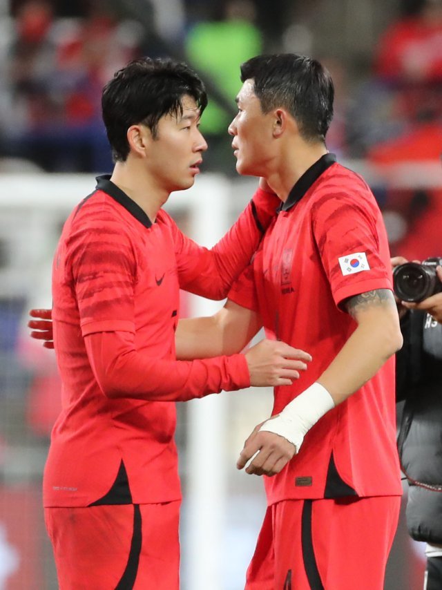 한국 축구대표팀 유니폼을 입은 손흥민과 김민재가 서로 격려하고 있는 장면이다.