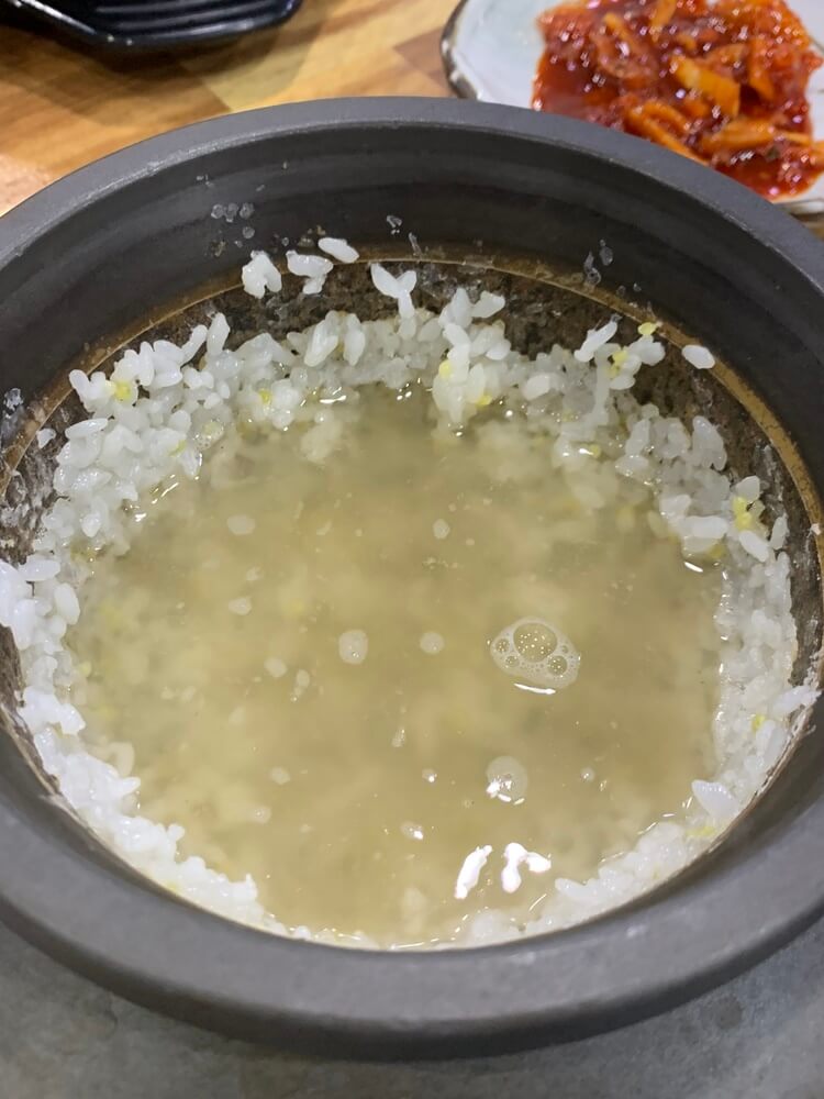 밥을 덜고 물을 넣어 만들고 있는 누룽지