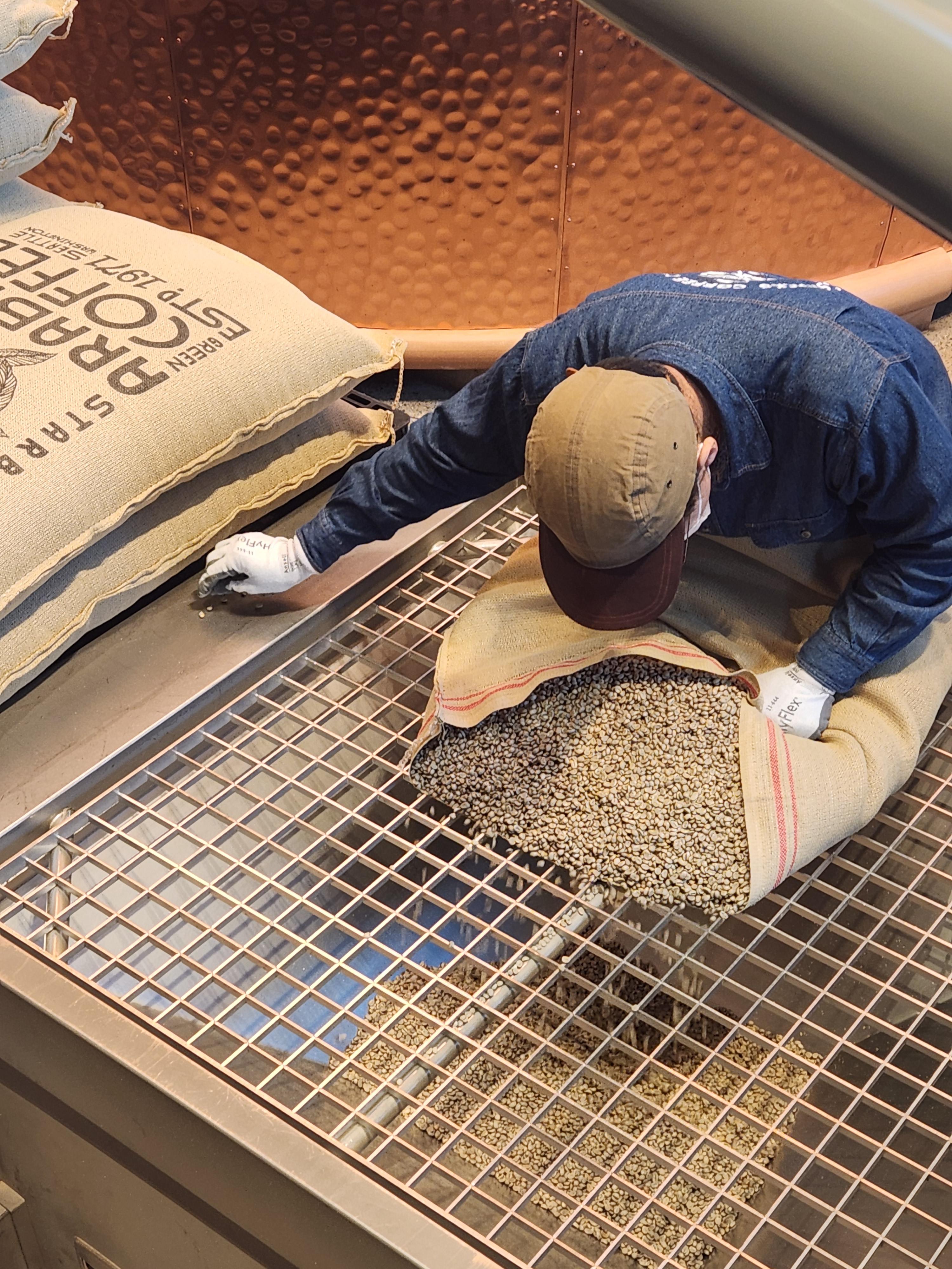 스타벅스 리저브 로스터리 도쿄에서 생두를 로스팅 기계에 투입하는 직원의 작업 모습 그린빈 작업