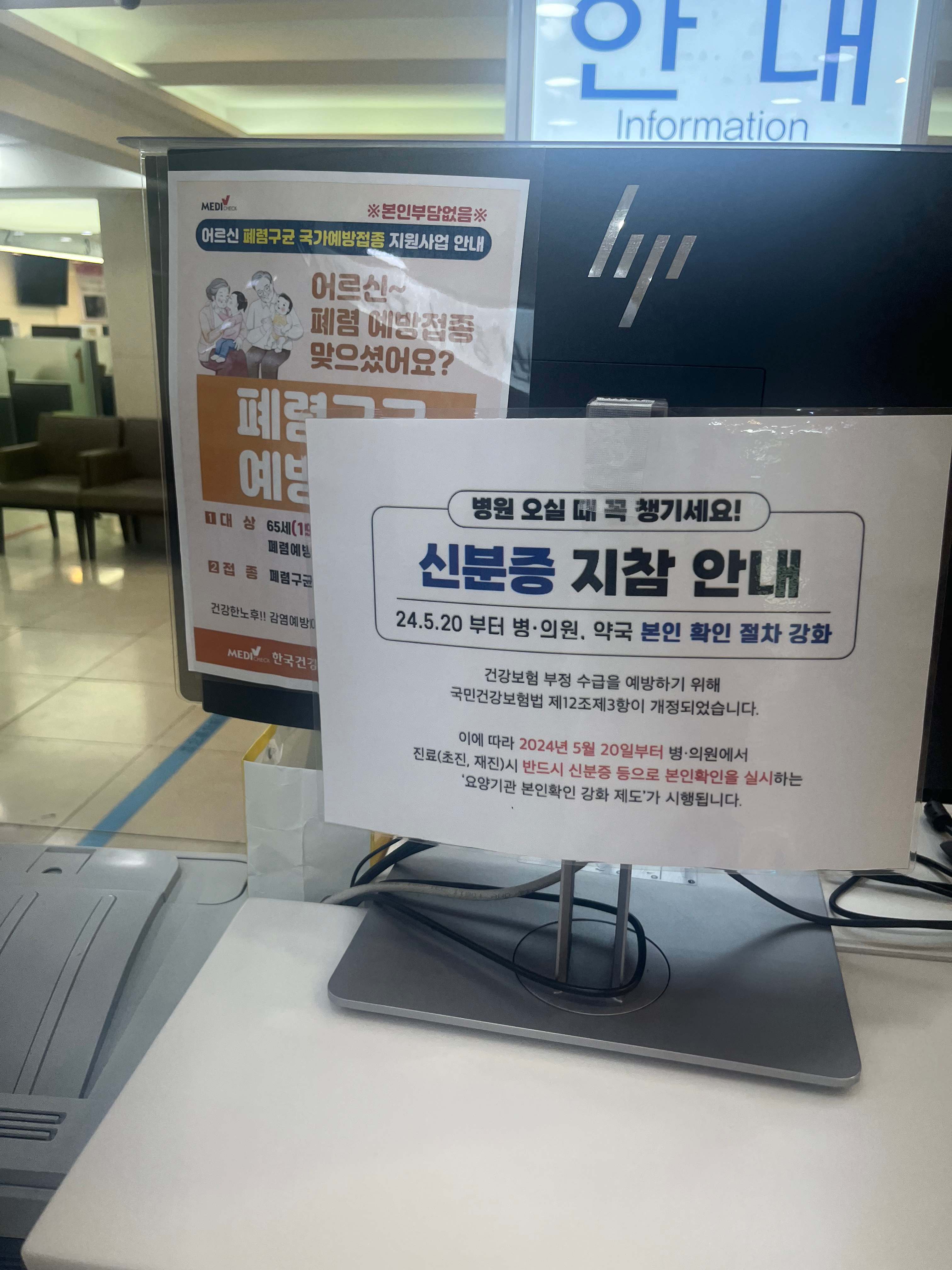 병원 데스크에 공지된 신분증 지참 안내 표지판