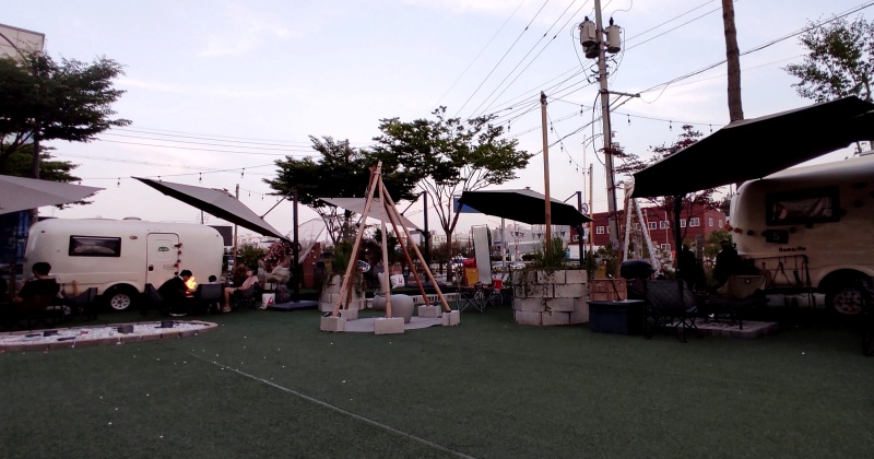 인조잔디와 캠핑카 파라솔 야외 화롯대등으로 장식된 야외공간