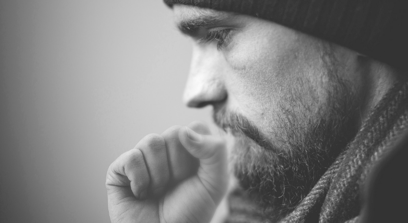 손으로 입을 가리고 기침을 하는 남성