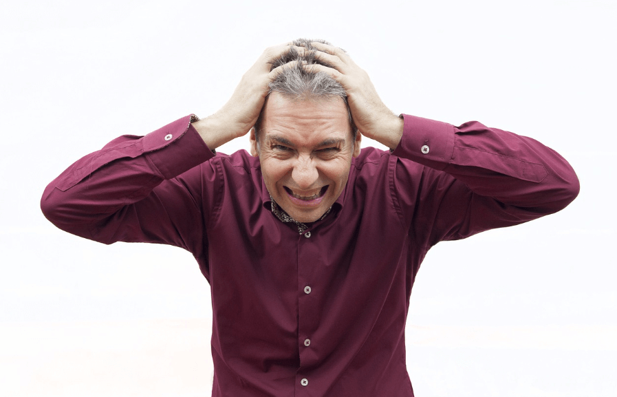 고민이 많아 머리를 잡아뜯고 있는 중년 남성